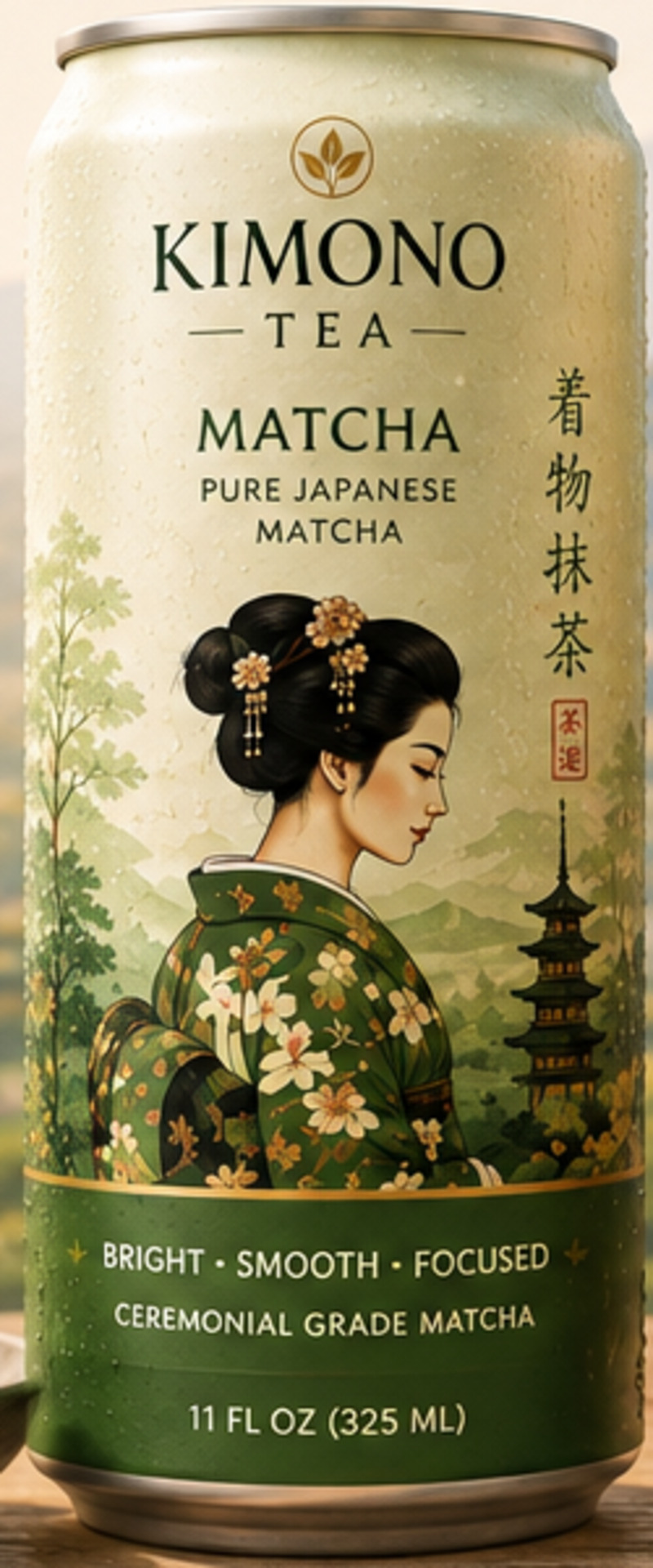 A chilled can of Kimono Tea Matcha beside a bowl of matcha powder and a bamboo whisk, cherry blossom and Mount Fuji beyond